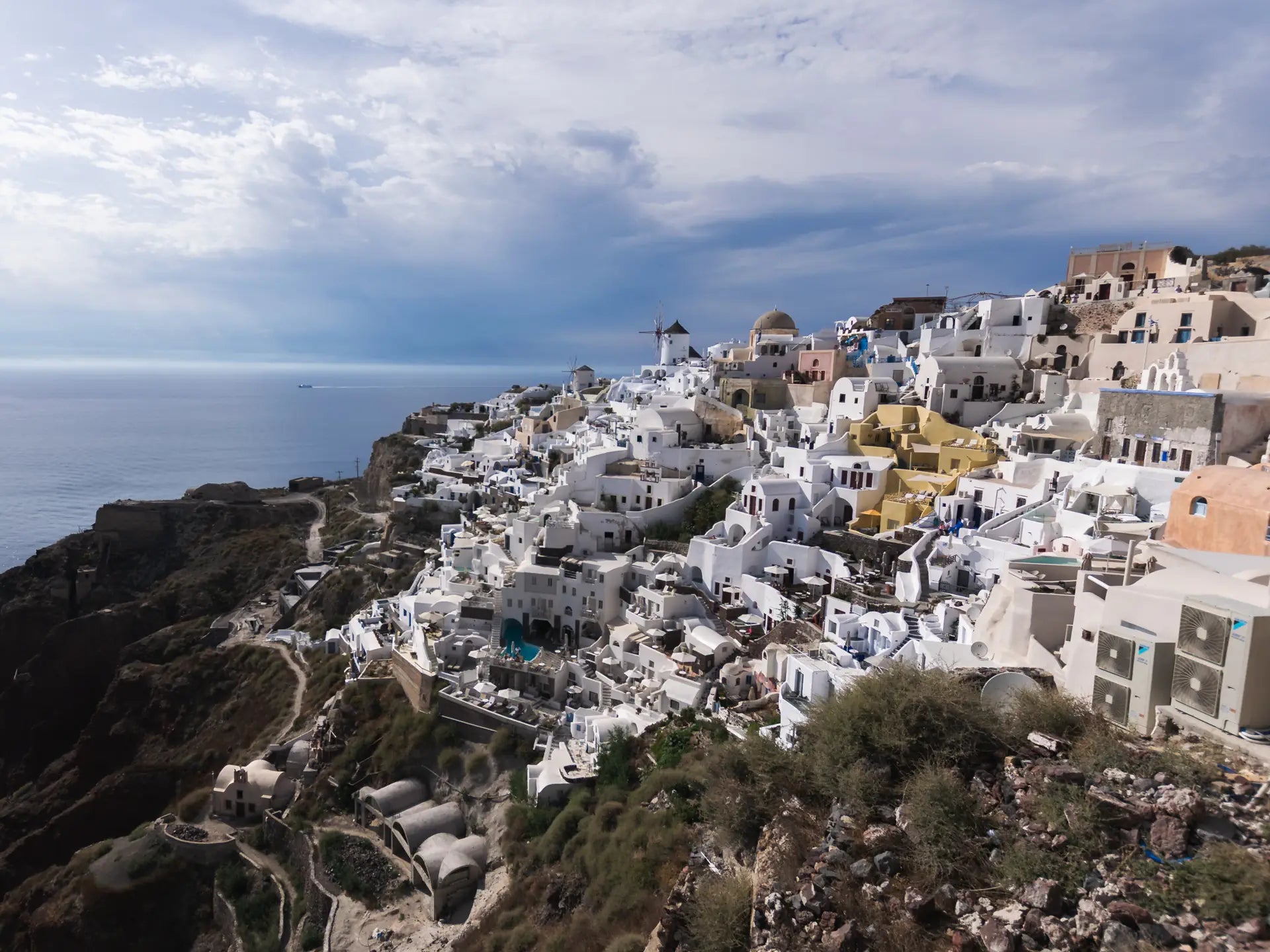 The view of the white cliffside village in Oia, Santorini in Greece on a bright day - London Canvas